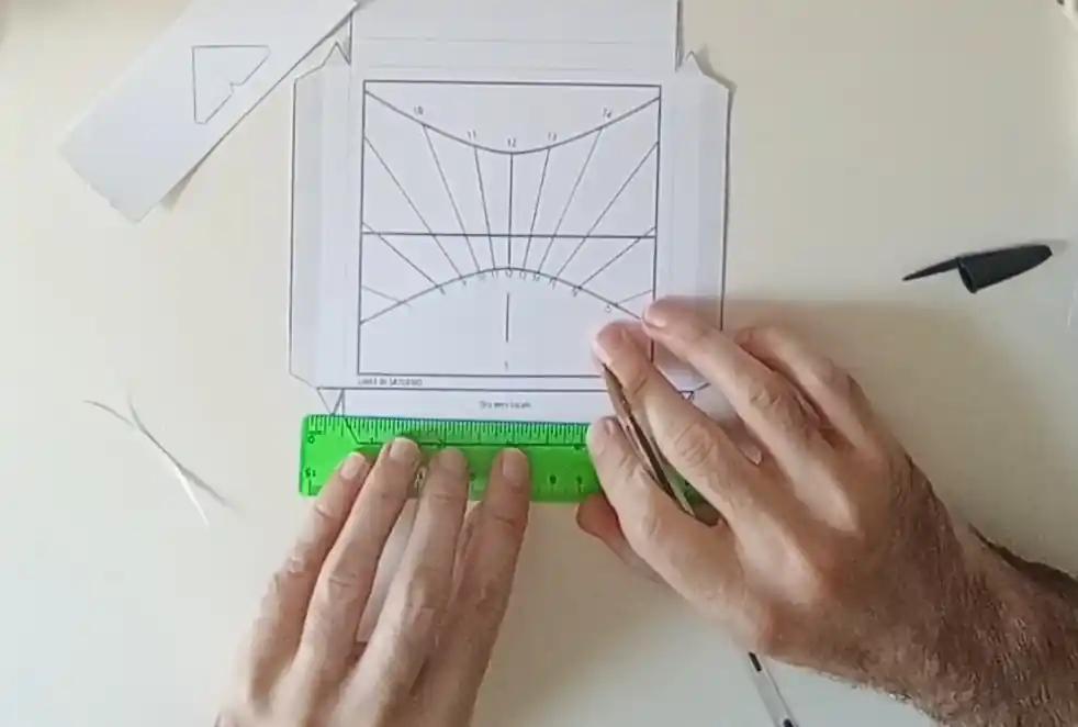 Preparazione delle linee di piega del template della meridiana con penna e righello